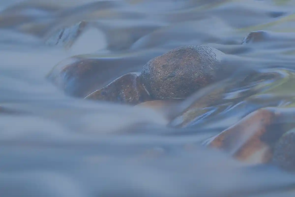 River rocks with water flowing image on recovery house website.